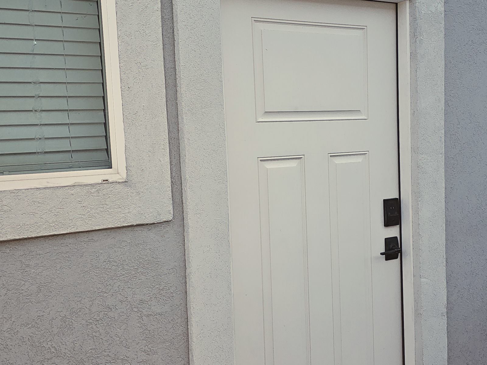 Finished exterior door with the stucco patch blended into the wall